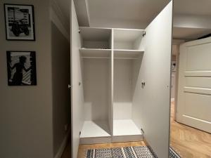 un vestidor con estanterías blancas en Svea Deluxe Apartment, en Estocolmo