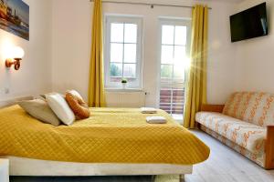 a bedroom with a yellow bed and a couch at Bursztynek in Władysławowo +18 photos