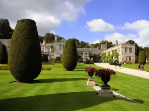 a garden with trees in front of a building at 1 Bed in Lanhydrock 88165 in Bodmin