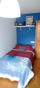 um quarto com uma cama com uma parede azul em Twin Room in shared Apartment em Cee