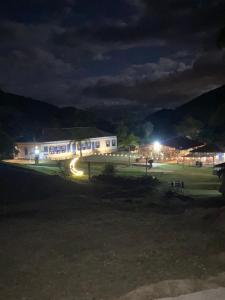 a building at night with lights in a field at Fazenda Penedo in Duas Barras