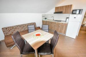 een keuken en eetkamer met een tafel en stoelen bij Apartments Ornella in Pašman