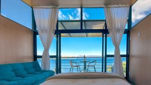 ein Schlafzimmer mit einem großen Fenster mit einem Sofa und einem Tisch in der Unterkunft Cabañas los Sauces in Tota