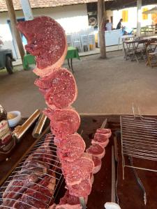 a bunch of meat is lined up on a grill at Fazenda Penedo in Duas Barras