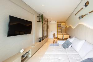 a bedroom with a bed and a tv on a wall at Apto 2Q moderno prox.da praia STL0702 in Balneário Camboriú