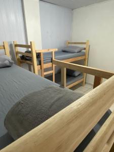 a room with two beds and a table and chairs at HOSTEL DA VILA in Santos