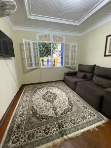 a living room with a couch and a rug at HOSTEL DA VILA in Santos