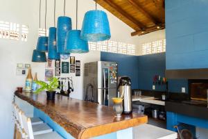 uma cozinha com luzes pendentes azuis e um balcão em Suite LIAM - Guest House Guaiu em Santa Cruz Cabrália
