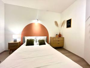1 dormitorio con 1 cama blanca grande y cabecero de madera en Le Mirror- hyper centre ville, en Sens