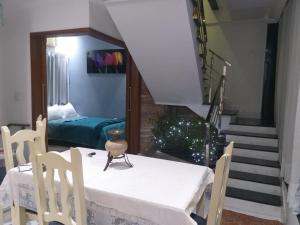 a dining room with a table and chairs and a staircase at Suite star in Duque de Caxias
