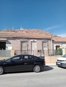 a black car parked in front of a house at Habitaciónes Privadas Cartagena Murcia in Cartagena