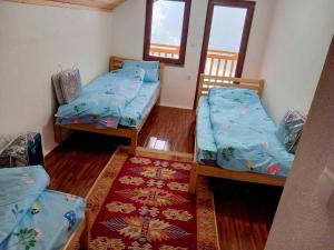 a small room with two beds and a rug at Villat Kroni Boge Rugove in Boge