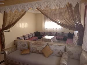 ein Wohnzimmer mit einem Sofa und einem Tisch in der Unterkunft Maison a louer par jour pour familles in Meknès