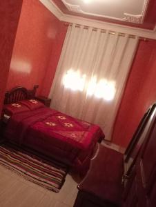 a red bedroom with a bed and a window at Maison a louer par jour pour familles in Meknès