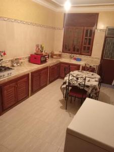 a kitchen with a table and a dining room at Maison a louer par jour pour familles in Meknès