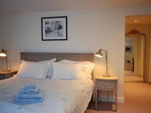 um quarto com uma cama com uma toalha azul em 3 Bed in Tetbury 44955 em Tetbury