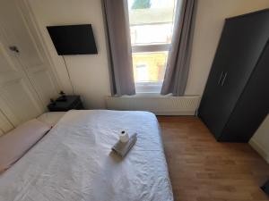 uma cama com um pato branco sentado em cima dela em Handsworth Hostel - Stay Sleep Rest em Birmingham