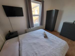 Un dormitorio con una cama blanca con un pato. en Handsworth Hostel - Stay Sleep Rest en Birmingham