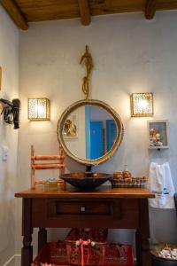 a bathroom with a sink and a mirror on the wall at Suite NOAH - Guest House Guaiu in Santa Cruz Cabrália