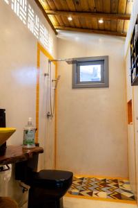 uma casa de banho com um chuveiro e um WC. em Suite NOAH - Guest House Guaiu em Santa Cruz Cabrália