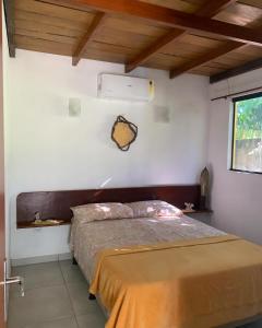 1 dormitorio con 1 cama en una pared blanca en Sítio Vila das Flores, en Tibau do Sul