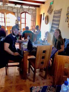 Un uomo e una donna seduti a un tavolo in un ristorante di Hostal Katarpe a San Pedro de Atacama