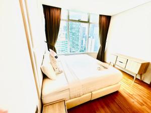 een slaapkamer met een bed en een groot raam bij Vortex Suites Near Klcc-365 in Kuala Lumpur