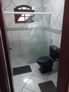 Ein Mann, der ein Bild von einer Toilette in einem Badezimmer macht. in der Unterkunft Guarus house plaza shopping in Campos dos Goytacazes