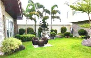 巴科洛德的住宿－Condo with direct access to shopping mall in Bacolod City，后院设有草坪,种植了家具和棕榈树