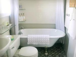 a bathroom with a tub and a toilet and a sink at Casita Charm, Cozy Character in Long Beach