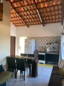 eine Küche mit einem Tisch und Stühlen sowie einem Kühlschrank in der Unterkunft Sítio Vila das Flores in Tibau do Sul
