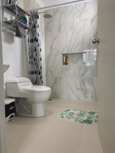 a white bathroom with a toilet and a shower at CASA JARDIN in Cancún