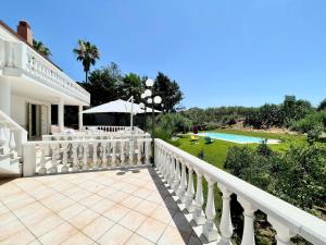 a white house with a balcony and a swimming pool at Villa Rachele con piscina in Balestrate