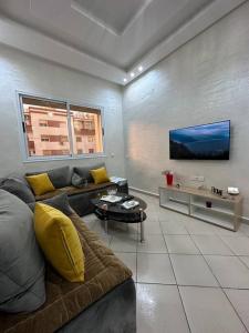 a living room with a couch and a tv at Appartement de lux à agadir in Agadir