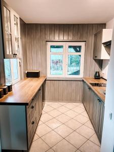 a kitchen with wood paneled walls and a window at Domek w Karpaczu in Karpacz