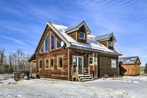 Cabaña de madera con nieve en el suelo en Off The Beaten Path Cabin with Mtn Views and Hot Tub en Red Lodge