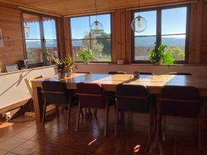 - une salle à manger avec une table, des chaises et des fenêtres dans l'établissement A Casa Amarela Guest room, à São Martinho da Cortiça