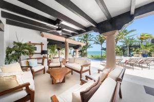 an outdoor patio with white furniture and a view of the ocean at Villa Albatros Oceanfront Luxury Hotelzone in Cancún