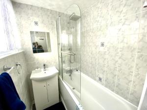 a bathroom with a shower and a sink and a toilet at Laret Guest House in London