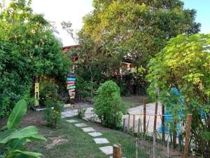 einen Garten mit einem Zaun und einigen Pflanzen und Bäumen in der Unterkunft Sítio Vila das Flores in Tibau do Sul