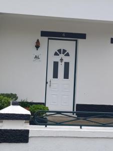 Una puerta blanca en una casa blanca con un negro en Casa da Atalaia en Angra do Heroísmo