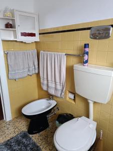 a bathroom with a toilet and a sink and towels at Casa da Atalaia in Angra do Heroísmo