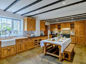 a large kitchen with wooden cabinets and a table at 5 Bed in Bingley 91977 in Bingley