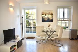 een woonkamer met een tafel en stoelen en een televisie bij Lux 2-Bed, Central, Balcony, Free Secure Parking in Reading