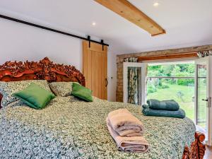 a bedroom with a large bed with green pillows at 1 Bed in Cullompton 92104 in Kentisbeare