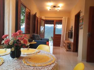 a dining room with a table with flowers on it at Chalé na Serra in Mulungu