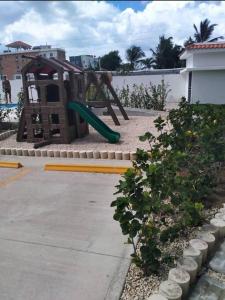 een speeltuin met een glijbaan in een tuin bij Beautiful condo in La Romana near Caleta beach in La Romana