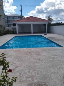a large blue swimming pool in front of a house at Beautiful condo in La Romana near Caleta beach in La Romana