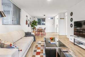 uma sala de estar com um sofá e uma mesa em EAST4 - Vintage Vibes East Freo 2B 1BA em Fremantle