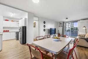 een keuken en een woonkamer met een tafel en stoelen bij EAST4 - Vintage Vibes East Freo 2B 1BA in Fremantle
